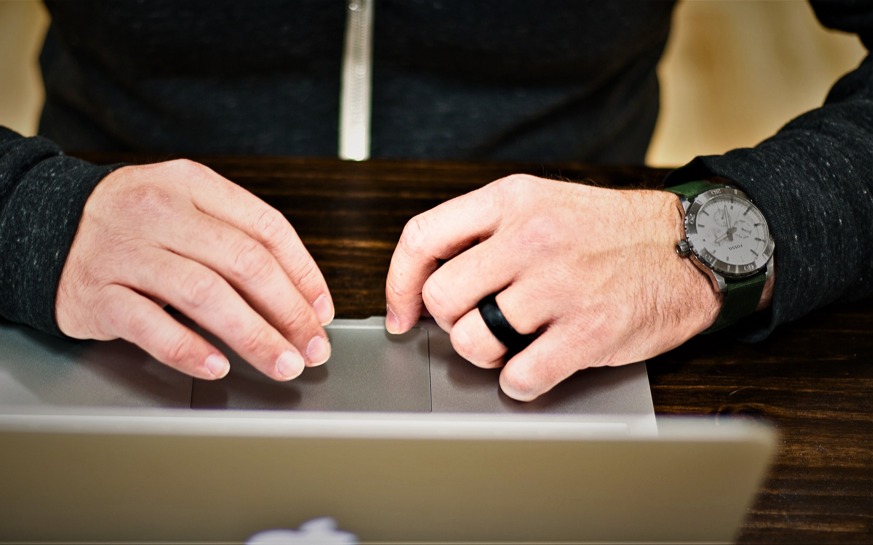 Black silicone ring by Dura Gear worn on hand while working on a laptop, comfortable and durable everyday ring